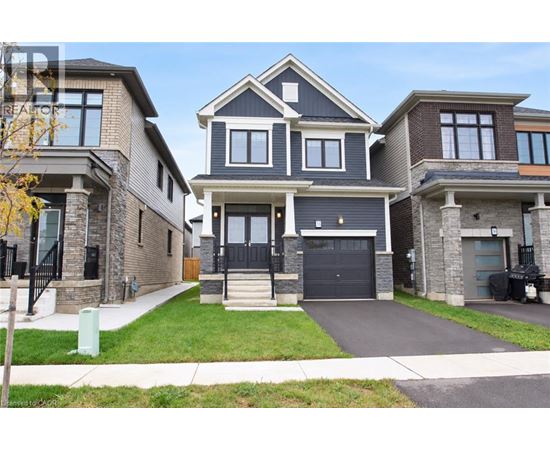 A large, modern house with a black front door and a garage.
