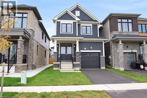 A large, modern house with a black front door and a garage.