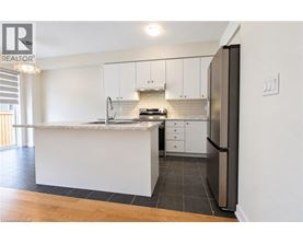 A modern kitchen with white cabinets and a marble countertop.