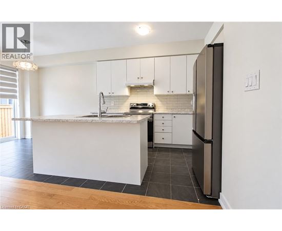 A modern kitchen with white cabinets and a marble countertop.
