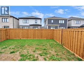 A backyard with a wooden fence and a grassy area.