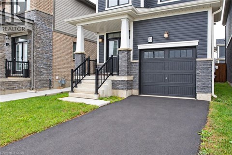 A house with a black garage door and a stone wall.