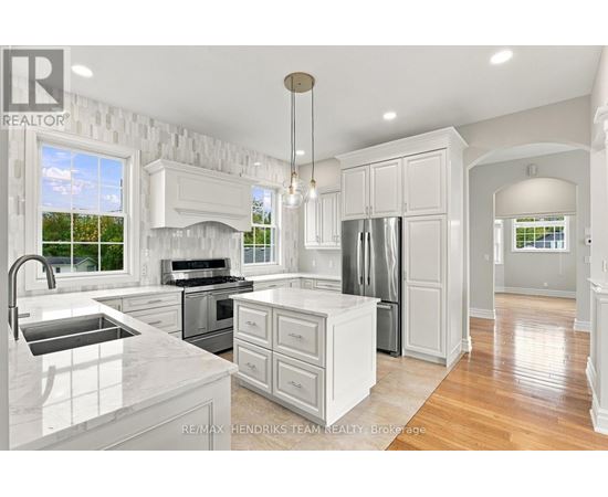 A modern kitchen with white cabinets and a marble countertop.