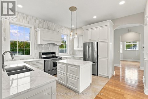 A modern kitchen with white cabinets and a marble countertop.