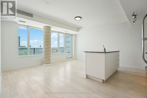 A spacious room with a reception desk and large windows.