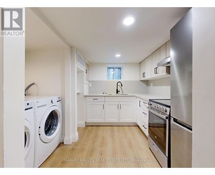 A modern kitchen with stainless steel appliances and white cabinets.