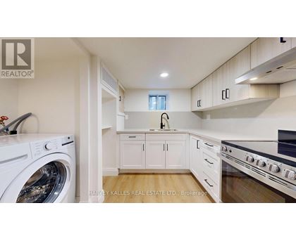 A modern kitchen with a washing machine and a stove top oven.