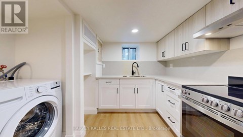 A modern kitchen with a washing machine and a stove top oven.