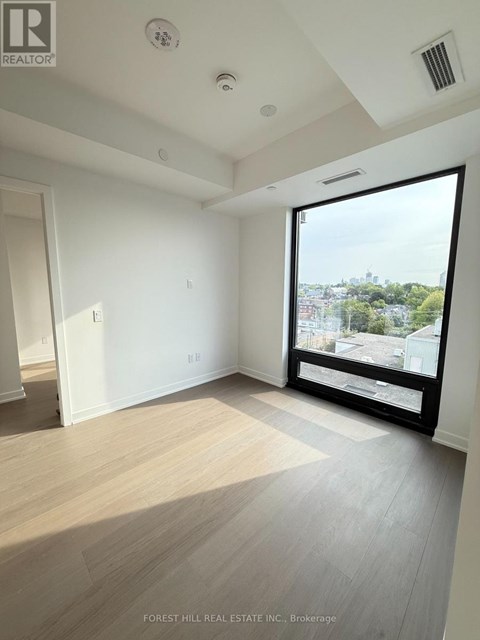 A room with a view of the city through a large window.