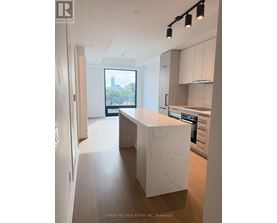 A modern kitchen with a marble island and wooden floors.