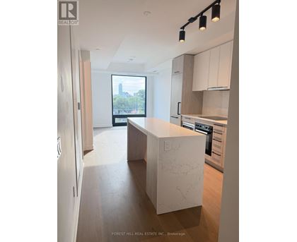 A modern kitchen with a marble island and wooden floors.