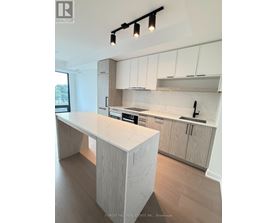 A modern kitchen with a marble countertop and wooden cabinets.