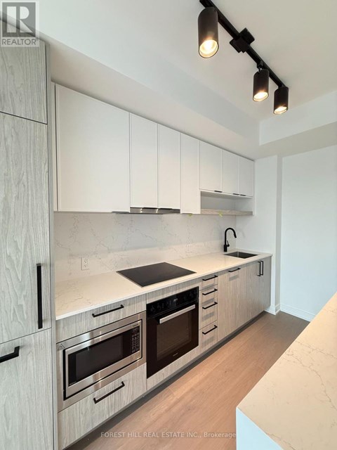 A modern kitchen with white cabinets and stainless steel appliances.