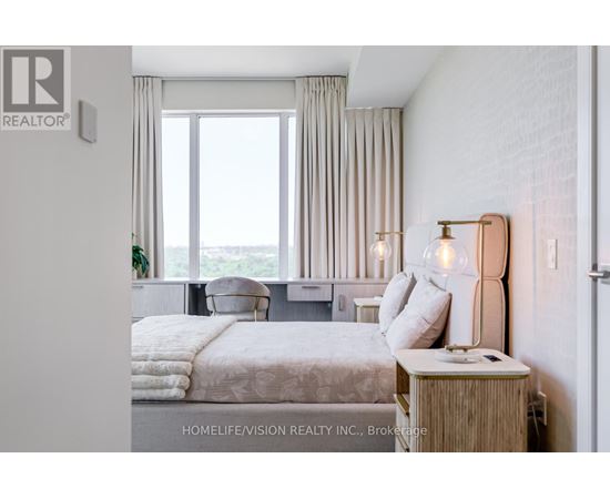 A bedroom with a large bed and a window overlooking the ocean.