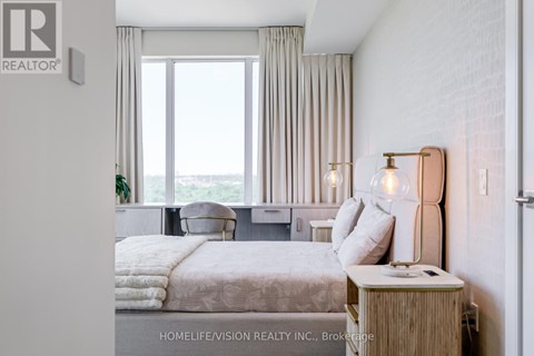 A bedroom with a large bed and a window overlooking the ocean.