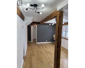 A room with wooden floors and a large wooden beam on the wall.