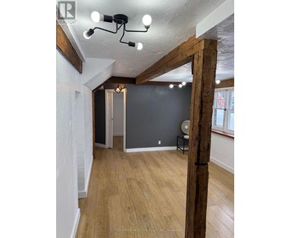 A room with wooden floors and a large wooden beam on the wall.