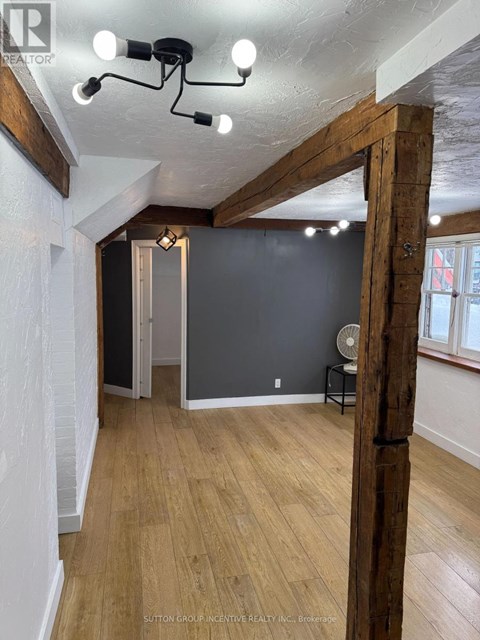 A room with wooden floors and a large wooden beam on the wall.