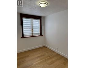A room with a window and wooden flooring.