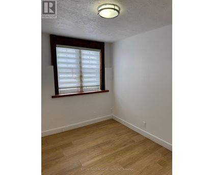 A room with a window and wooden flooring.
