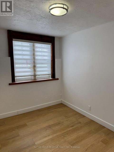 A room with a window and wooden flooring.
