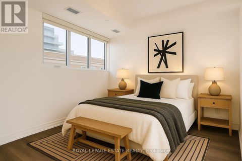A bedroom with a bed, nightstands, and a rug.