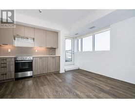 A kitchen with wooden floors and a stainless steel oven.
