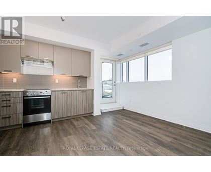 A kitchen with wooden floors and a stainless steel oven.