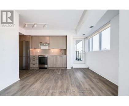 A spacious kitchen with wooden floors and modern appliances.