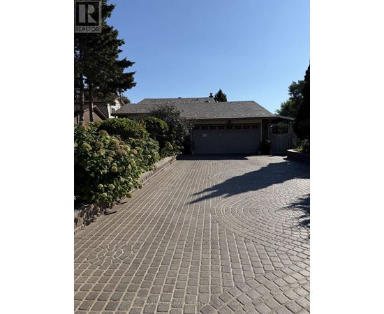 A driveway with a circular pattern leading to a garage.