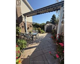 A patio with a table and chairs under a pergola.