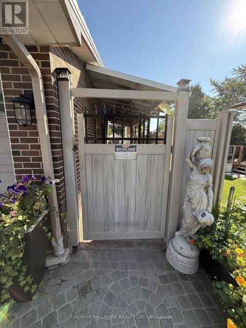 A wooden gate with a sign on it and a statue in front of it.