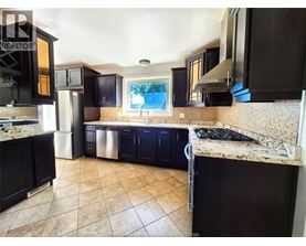 A kitchen with black cabinets and a tiled floor.
