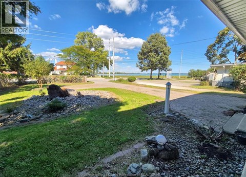 A sunny day at a residential area with a house and a tree in the background.