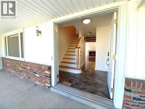 A house with a staircase leading to the second floor is for sale.
