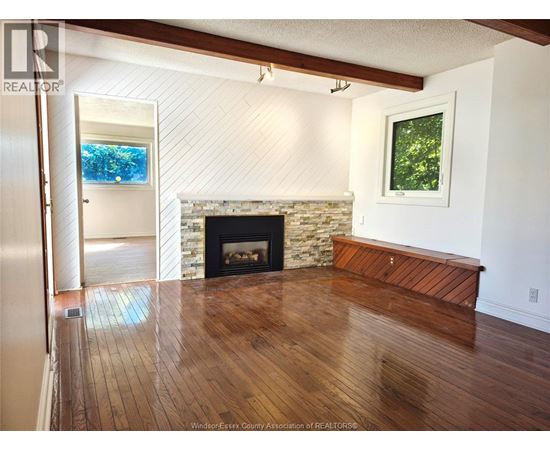 A living room with a fireplace and a painting on the wall.