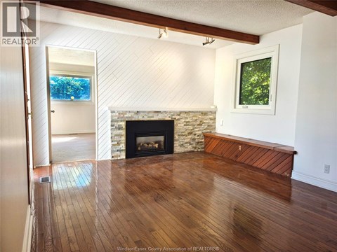 A living room with a fireplace and a painting on the wall.