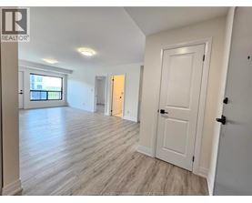 A spacious room with wooden flooring and white walls.