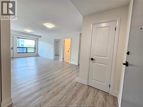 A spacious room with wooden flooring and white walls.