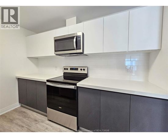 A kitchen with a stove top oven and microwave.