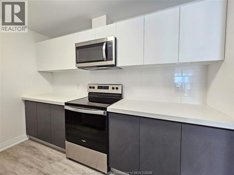 A kitchen with a stove top oven and microwave.