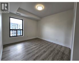 A room with a window and wooden flooring.