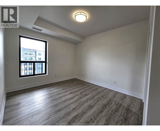 A room with a window and wooden flooring.