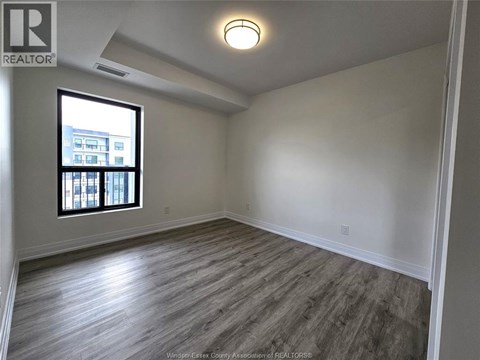 A room with a window and wooden flooring.