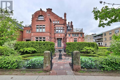 A red brick building with a gate in front.