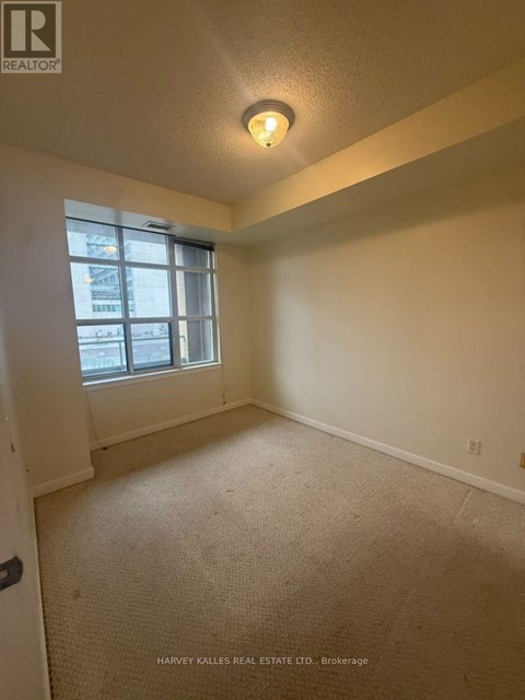 A room with a carpeted floor and a window.
