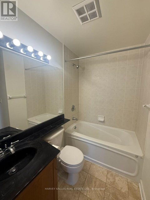 A bathroom with a toilet, sink, and bathtub.