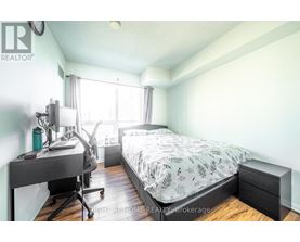 A bedroom with a bed, desk, and chair.