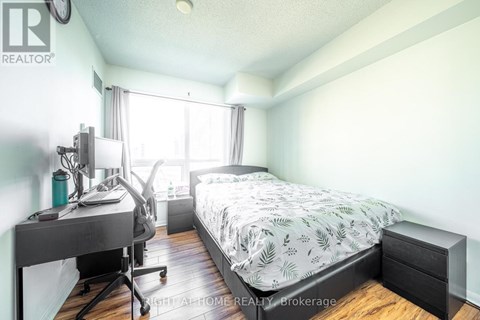 A bedroom with a bed, desk, and chair.