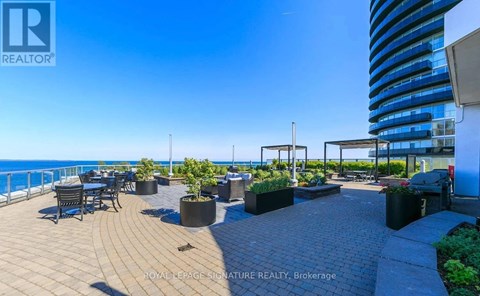 A balcony with a table and chairs overlooking the sea.